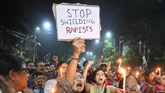 Medical professionals and activists hold posters and candles as they take part in a midnight protest to condemn the rape and murder of a young medic, in Kolkata. (AFP)