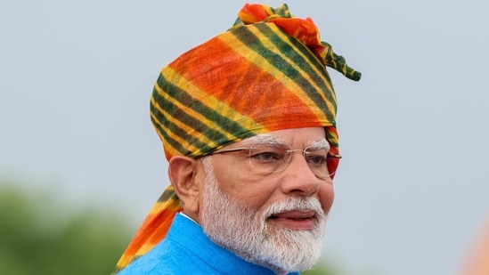 Donning a colourful Rajasthani leheriya turban, a white kurta and blue jacket, PM Modi hoisted the tiranga, while paying homage to the colours of the flag with his outfit as well(Arvind Yadav/Hindustan Times)
