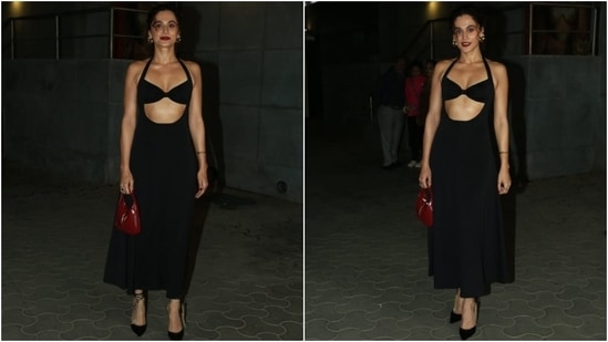 Taapsee Pannu wore a black halter-neck midi dress to the premiere of Khel Khel Mein. She styled the cut-out ensemble with bold red lips, Jimmy Choo stilettos, a red Gucci bag, hoop earrings, and a messy top knot.&nbsp;(HT Photo/Varinder Chawla)