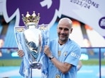 Manchester City's head coach Pep Guardiola celebrates with the Premier League trophy. Manchester City's head coach Pep Guardiola celebrates with the Premier League trophy.