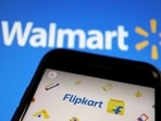 A mobile phone showing an image of Indian online retailer Flipkart is seen in front of a Walmart Inc logo displayed.