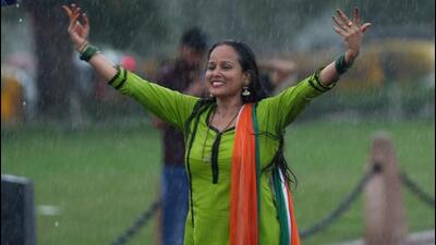 A woman enjoys the rain at Kartavya Path in New Delhi. (PTI Photo)