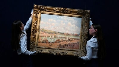 Two members of staff hold the painting by late Franco-Danish painter Camille Pissaro "Darse de peche et bassin Duquesne, Dieppe, apres-midi ensoleillee" (Fishing dock and Duquesne basin, Dieppe, sunny afternoon) during the photocall at the Sotheby's auction house, in central London, on June 19, 2024 ahead of the Sotheby's major Modern & Contemporary art auction of the summer season. (Justin Tallis/AFP) (AFP) Two members of staff hold the painting by late Franco-Danish painter Camille Pissaro "Darse de peche et bassin Duquesne, Dieppe, apres-midi ensoleillee" (Fishing dock and Duquesne basin, Dieppe, sunny afternoon) during the photocall at the Sotheby's auction house, in central London, on June 19, 2024 ahead of the Sotheby's major Modern & Contemporary art auction of the summer season. (Justin Tallis/AFP) (AFP)