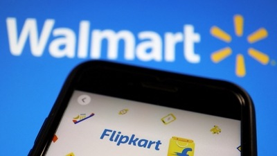 A mobile phone showing an image of Indian online retailer Flipkart is seen in front of a Walmart Inc logo displayed. (Reuters)