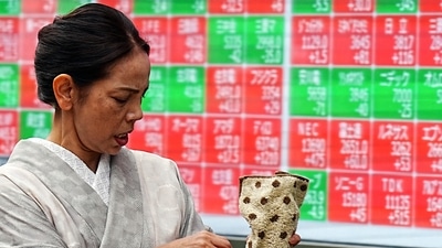A person walks in front of an electronic stock board showing Japan's Nikkei index at a securities firm in Tokyo. (AP) A person walks in front of an electronic stock board showing Japan's Nikkei index at a securities firm in Tokyo. (AP)