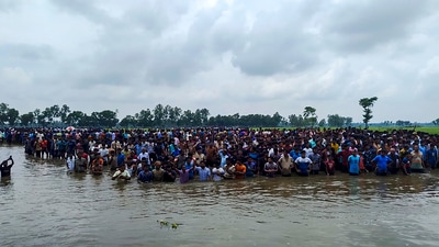 Cooch Behar: Bangladeshi nationals assemble close to the Sitalkuchi fenced land border in Cooch Behar in their bid to crossover to India. (PTI Photo) (PTI)