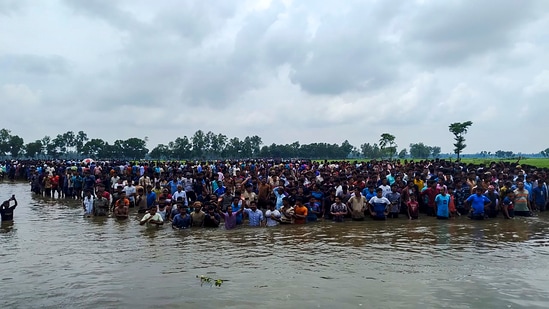 Cooch Behar: Bangladeshi nationals assemble close to the Sitalkuchi fenced land border in Cooch Behar in their bid to crossover to India. (PTI Photo)(PTI)