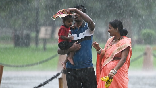 Visitors at Kartavya Path amid monsoon rain in New Delhi, India. Monsoon season health guide: Expert tips on managing viral fever and infections during rainy season (Photo by Sanjeev Verma/Hindustan Times)