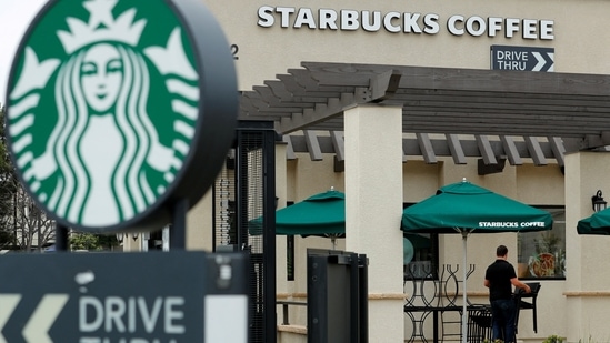 An employee clears away patio furniture at a Starbucks Corp. drive-thru branch in Oceanside, California, U.S. May 29, 2018 (Mike Blake/Reuters)