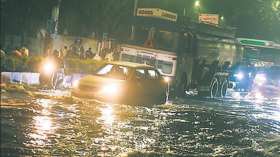 vehicles pass through waterlogged road at near Pune collector’s office on Saturday. (MAHENDRA KOLHE/HT PHOTO)