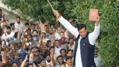 Devendra Yadav waves a flag and a book of constitution following his arrest on Saturday (Twitter Photo) Devendra Yadav waves a flag and a book of constitution following his arrest on Saturday (Twitter Photo)