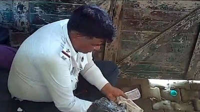 Three traffic policemen were caught on camera dividing money they took as a bribe. (Screengrab) Three traffic policemen were caught on camera dividing money they took as a bribe. (Screengrab)