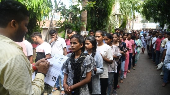 अधिकारी पटना में बिहार पुलिस कांस्टेबल परीक्षा के लिए इंतजार कर रहे उम्मीदवारों के विवरण की जांच करते हैं। (संतोष कुमार)