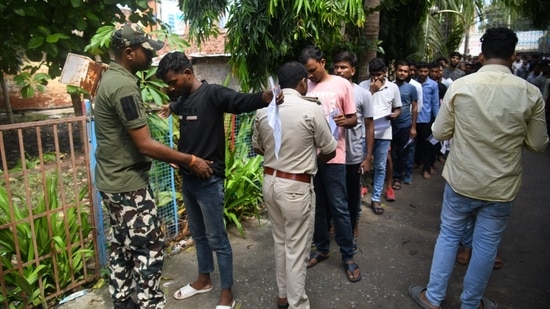 पटना में बिहार पुलिस कांस्टेबल परीक्षा में शामिल होने के लिए परीक्षा हॉल में प्रवेश करने से पहले सुरक्षा अधिकारी अभ्यर्थियों की तलाशी लेते नजर आए। (संतोष कुमार)