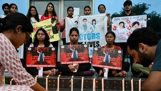 Medical professionals light candles as they pay tribute to a victim of the rape and murder of a young medic from Kolkata, in Amritsar on August 18, 2024. (Photo by Narinder NANU / AFP) (AFP)