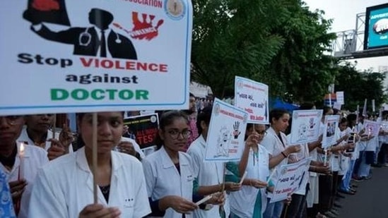 Kolkata rape-murder: Doctors and medical students hold placards and candles during a protest (AP Photo)