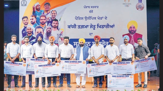 Punjab chief minister Bhagwant Mann with Paris Olympics bronze medallist men's hockey team during a felicitation ceremony in Chandigarh, Sunday (PTI)