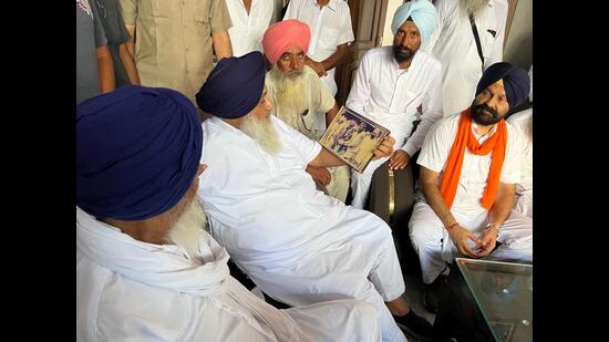 SAD President Sukhbir Singh Badal looks at a picture of his father during a meeting with people from his constituency on Sunday. (HT Photo)