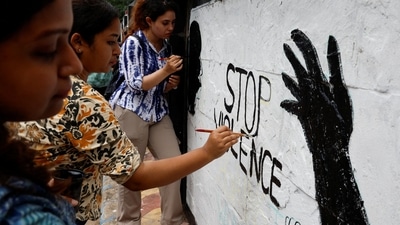 Medics paint slogans inside Kolkata Medical College and Hospital campus condemning the rape and murder of a trainee medic at a government-run hospital, in Kolkata. (Reuters)