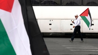 An Iranian man, carrying a Palestinian flag, walks to attend the funeral ceremony of Hamas leader Ismail Haniyeh and his bodyguard who were killed in an assassination blamed on Israel on Wednesday, at Enqelab-e-Eslami (Islamic Revolution) Sq. in Tehran, Iran, Thursday, Aug. 1, 2024. (AP Photo/Vahid Salemi) (AP) An Iranian man, carrying a Palestinian flag, walks to attend the funeral ceremony of Hamas leader Ismail Haniyeh and his bodyguard who were killed in an assassination blamed on Israel on Wednesday, at Enqelab-e-Eslami (Islamic Revolution) Sq. in Tehran, Iran, Thursday, Aug. 1, 2024. (AP Photo/Vahid Salemi) (AP)