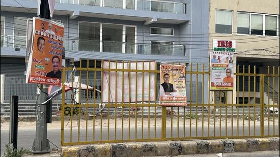 Political posters displayed for the upcoming assembly elections in Haryana on the Gurugram Sector 15 road on Monday. (Parveen Kumar/HT Photo)