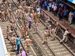 Thane: Police personnel try to disperse people blocking railway tracks in protest against the alleged sexual abuse of two girls at a school, at Badlapur railway station.