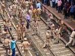 Thane: Police personnel try to disperse people blocking railway tracks in protest against the alleged sexual abuse of two girls at a school, at Badlapur railway station.
