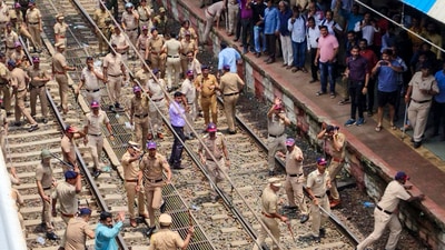 Thane: Police personnel try to disperse people blocking railway tracks in protest against the alleged sexual abuse of two girls at a school, at Badlapur railway station. (PTI) Thane: Police personnel try to disperse people blocking railway tracks in protest against the alleged sexual abuse of two girls at a school, at Badlapur railway station. (PTI)