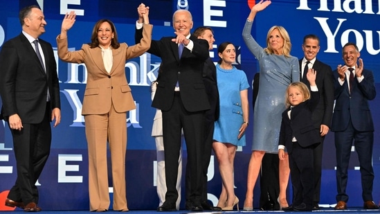 Joe Biden holds the hand of U.S. Vice President and 2024 Democratic presidential candidate Kamala Harris after delivering the keynote address on the first day of the Democratic National Convention (DNC) at the United Center in Chicago, Illinois, August 19, 2024, as the Biden family stands nearby. (AFP)