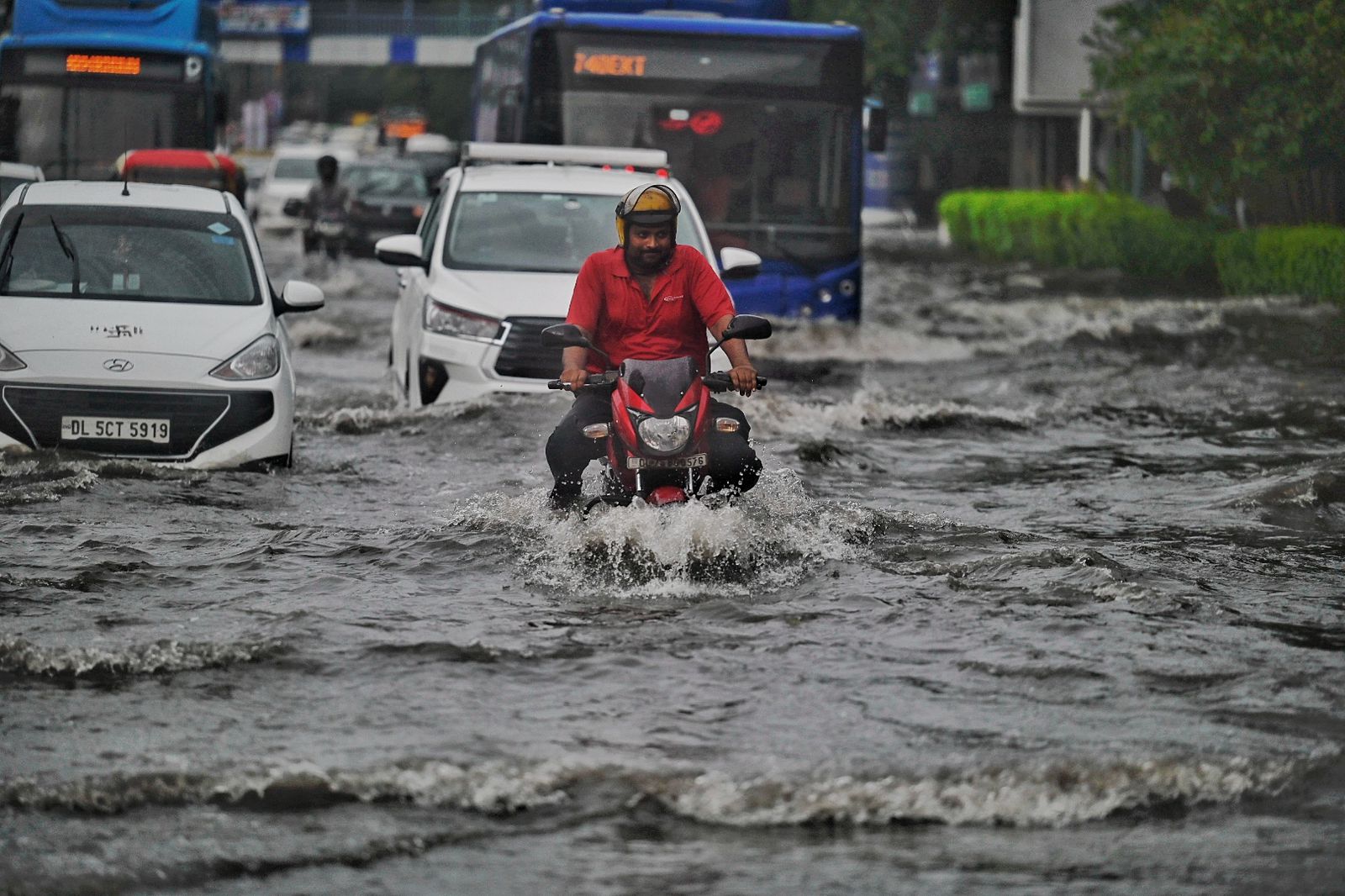 Commuters step out during morning rain, at ITO India, on Tuesday, August 20, 2024. (Photo by Raj j K Raj / Hindustan Times)