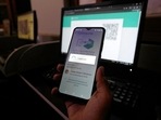 A Pakistani waits to connect his mobile WhatsApp with a desktop as internet runs slow past several days, in Karachi, Pakistan, Monday, Aug. 19, 2024. (AP Photo/Fareed Khan)