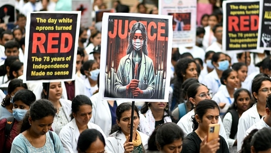 Medical professionals hold posters at a hospital in Bengaluru amid nationwide strike by doctors to condemn the rape and murder of a young medic from Kolkata.(AFP)