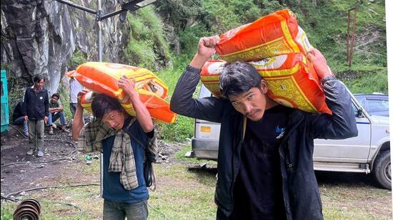 Laborers have been carrying essentials to the village on foot since the connectivity was snapped. (Aqil Khan/HT)