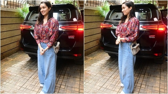 Shraddha Kapoor wears a printed cropped blouse and baggy light blue denim jeans for an outing in the city. She chose loose tresses, a mini over-the-body bag, white sneakers, and a no-makeup look to style the ensemble.&nbsp;(HT Photo/Varinder Chawla)