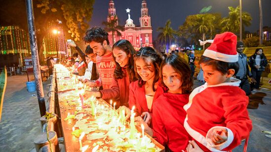 भारत येथे सोमवारी ख्रिसमस डे उत्सवादरम्यान सेक्रेड हार्ट कॅथेड्रल चर्चमध्ये मेणबत्त्या पेटवताना भाविक.