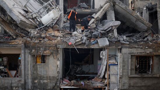 Palestinians inspect the site of an Israeli strike on a house, amid the ongoing conflict between Israel and Hamas, in Rafah town in the southern Gaza Strip