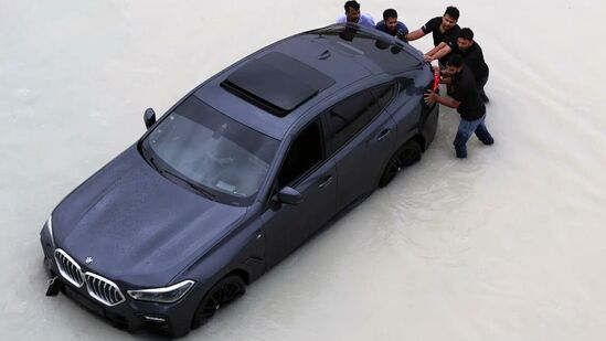 मुसळधार पावसामुळे पाण्यात अडकलेल्या महागड्या कारला बाहेर काढण्यासाठी तिथले लोक आटोकाट प्रयत्न करत असतांना टिपलेले हे छायाचित्र.&nbsp;