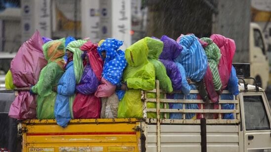 People travel in a tempo amid pre-monsoon showers in Chikkamagaluru, Karnataka, on Monday. (PTI Photo)