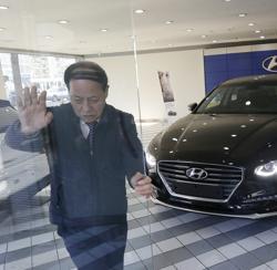 A worker opens the door to bring Hyundai Motor Co.'s Grandeur out to put it on display for sale, at its showroom in Seoul, South Korea. A worker opens the door to bring Hyundai Motor Co.'s Grandeur out to put it on display for sale, at its showroom in Seoul, South Korea.