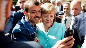 An asylum seeker takes a selfie with German Chancellor Angela Merkel following her visit to a branch of the Federal Office for Migration and Refugees and a camp for refugees in Berlin, 2017(AFP) An asylum seeker takes a selfie with German Chancellor Angela Merkel following her visit to a branch of the Federal Office for Migration and Refugees and a camp for refugees in Berlin, 2017(AFP)