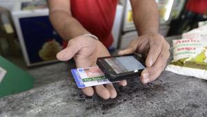 A staff member scans a prepaid smart card at a Mother Dairy store, at Bhatt village on the outskirts of Ahmedabad. The government has decided to “exempt services by an acquiring bank to any person in relation to settlement of an amount up to Rs 2,000 in a single transaction through credit, debit card or other payment card service”.(AFP) A staff member scans a prepaid smart card at a Mother Dairy store, at Bhatt village on the outskirts of Ahmedabad. The government has decided to “exempt services by an acquiring bank to any person in relation to settlement of an amount up to Rs 2,000 in a single transaction through credit, debit card or other payment card service”.(AFP)
