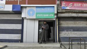 A man emerges from an ATM in Sopore in north Kashmir after withdrawing money. After demonetisation, queues outside banks and ATMs in Kashmir have been without rush unlike that in other parts of the country.(Waseem Andrabi/Hindustan Times) A man emerges from an ATM in Sopore in north Kashmir after withdrawing money. After demonetisation, queues outside banks and ATMs in Kashmir have been without rush unlike that in other parts of the country.(Waseem Andrabi/Hindustan Times)