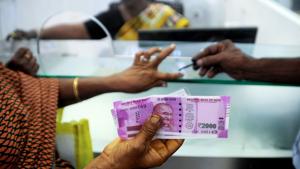 A woman displays her 2000-rupee notes as she has her finger inked with indelible ink after exchanging old notes at a bank in Chennai.(AFP Photo) A woman displays her 2000-rupee notes as she has her finger inked with indelible ink after exchanging old notes at a bank in Chennai.(AFP Photo)
