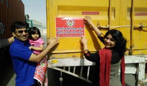 HN Meena and his wife Prof Hemlata Meena put stickers on a truck as part of their campaign in Neemuch.(HT photo)