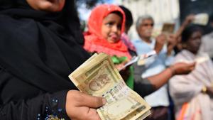 People waiting to exchange demonetised currency, show their old 500 and 1000 Rupee notes near the closed gates of Reserve Bank of India in Bangalore.(AFP Photo) People waiting to exchange demonetised currency, show their old 500 and 1000 Rupee notes near the closed gates of Reserve Bank of India in Bangalore.(AFP Photo)