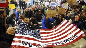 Protestors hold up an American flag at the airport.(AP Photo)