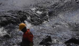 A firefighter stands beside a thick oily tide from the sea lapping the coast, after an oil tanker and an LPG tanker collided off Kamarajar Port in Ennore, in Chennai on Febuary 4.(AFP) A firefighter stands beside a thick oily tide from the sea lapping the coast, after an oil tanker and an LPG tanker collided off Kamarajar Port in Ennore, in Chennai on Febuary 4.(AFP)