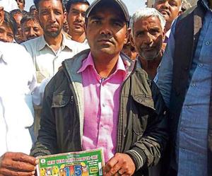 Azad Singh showing his lottery ticket and the lottery ticket number that matched.(HT Photo) Azad Singh showing his lottery ticket and the lottery ticket number that matched.(HT Photo)