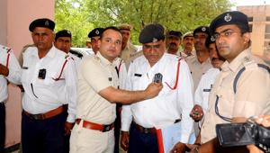 Rohtak superintendent of police Pankaj Nain fitting a body camera on a traffic cop in Rohtak on Tuesday .(Manoh Dhaka/HT Photo) Rohtak superintendent of police Pankaj Nain fitting a body camera on a traffic cop in Rohtak on Tuesday .(Manoh Dhaka/HT Photo)
