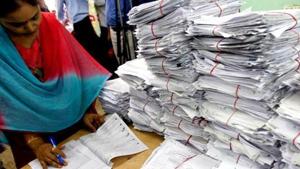 Tax officials scrutinising a tax return form in New Delhi.(AFP File Photo) Tax officials scrutinising a tax return form in New Delhi.(AFP File Photo)